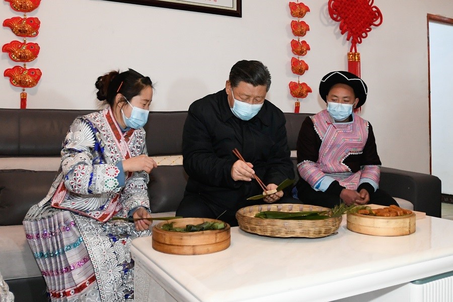 2021年2月3日下午，習(xí)近平在貴州畢節(jié)市黔西縣新仁苗族鄉(xiāng)化屋村苗族村民趙玉學(xué)家，同一家人邊聊家常邊制作當(dāng)?shù)貍鹘y(tǒng)節(jié)日食品黃粑。新華社記者 李學(xué)仁 攝