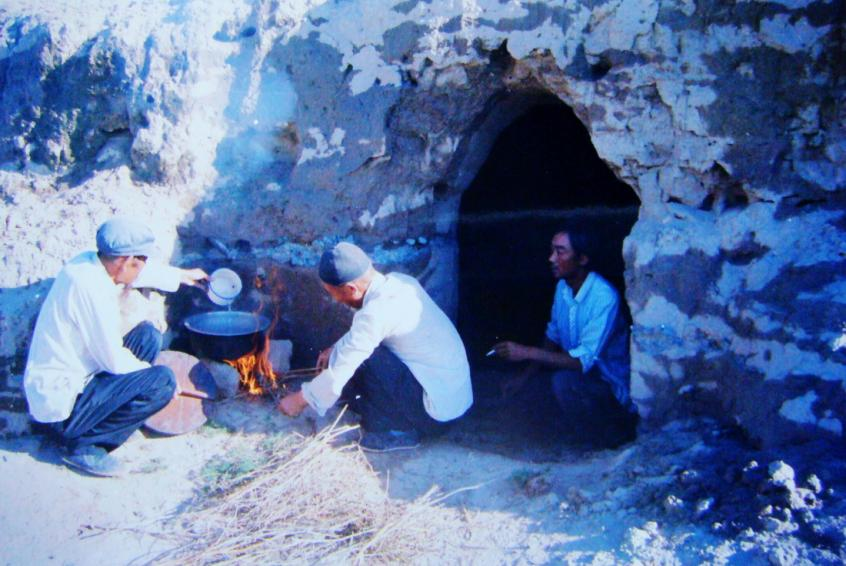1983年，“六老漢”一代治沙人在“地窩子”生活做飯。新華社發(fā)（八步沙林場供圖）